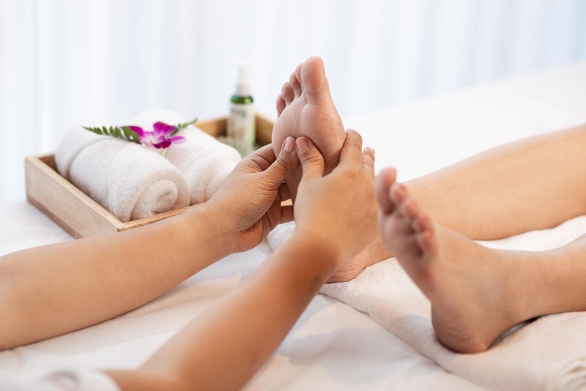 A woman enjoying a 4-hands Indian foot massage in Bangkok