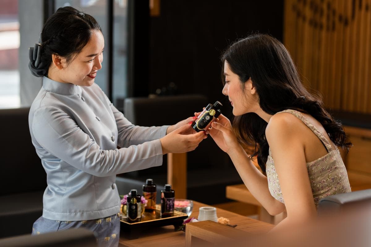 A woman choosing aroma oils for her massage session